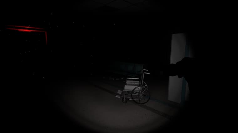 A wheelchair caught in the flashlight beam in an otherwise pitch black waiting area.